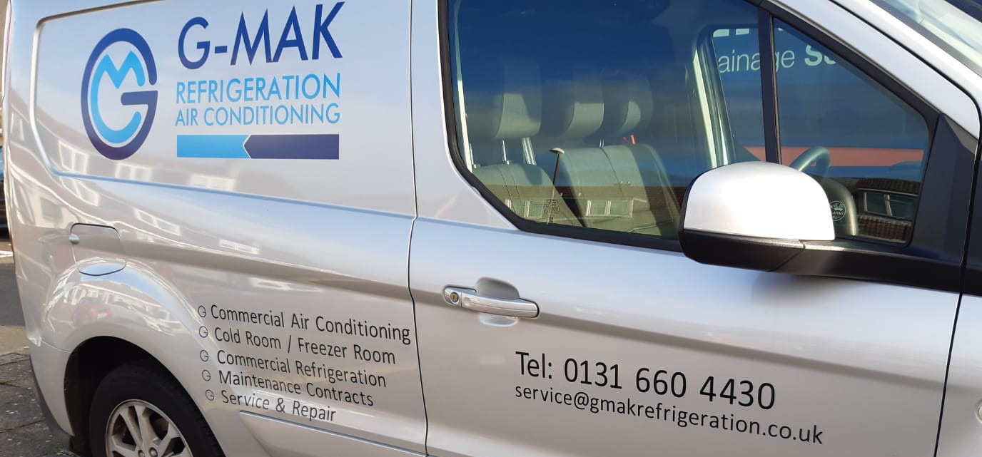 A silver van with blue writing on it