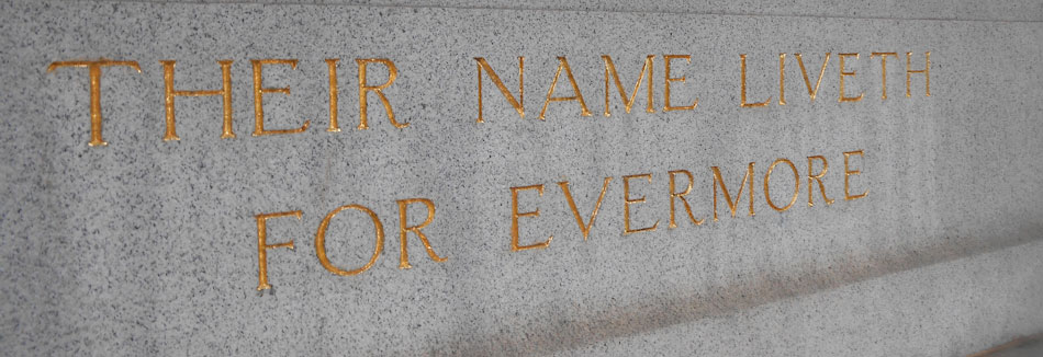 An engraving in gray marble with gold leaf that reads: Their Name Liveth For Evermore