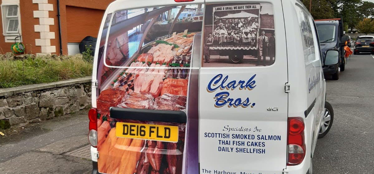 A white van with a vinyl photo of fish in a fishmongers